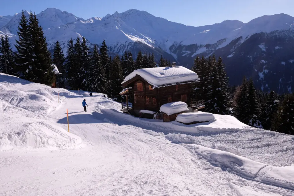 Chalet suisse sous la neige avec snowboarder à Verbier