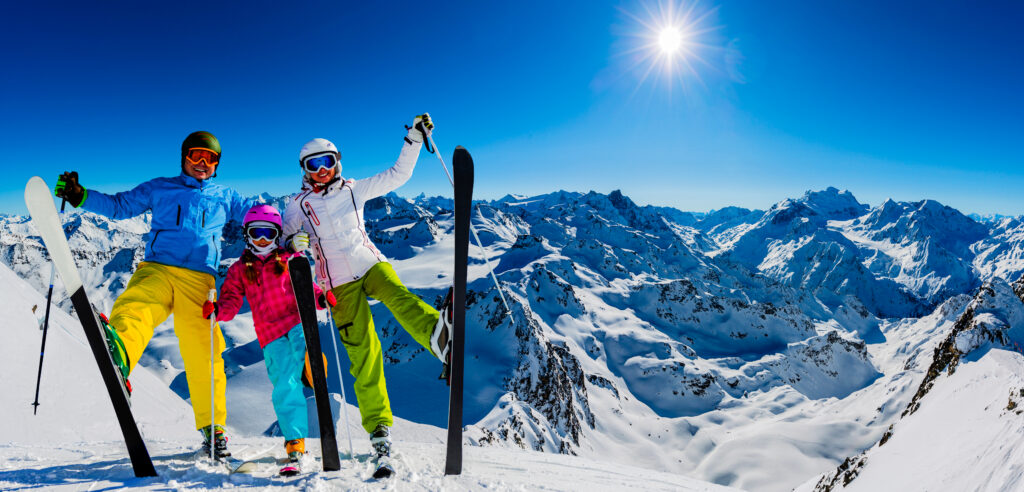 Famille de skieurs sur fond de sommets enneigés