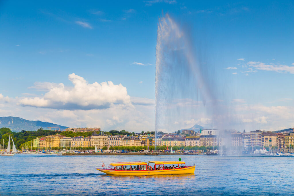 Bateau jaune traversant le lac de Genève devant le Jet d’eau