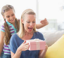 Jeune fille surprenant sa mère avec un cadeau à la maison