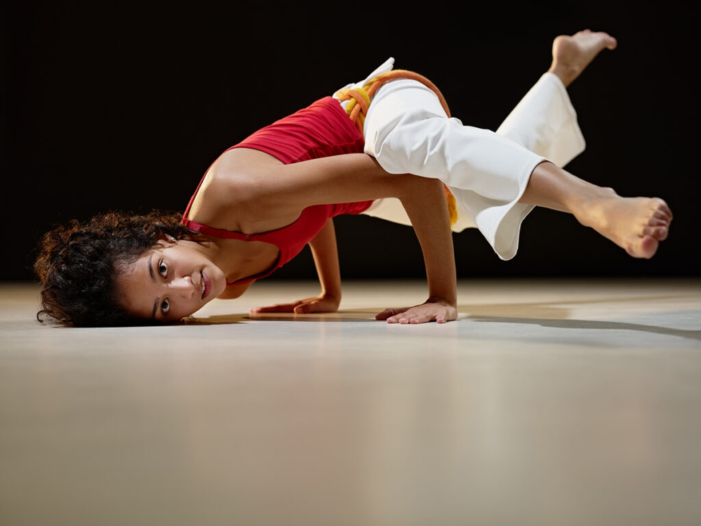 Jeune fille faisant de la capoeira en salle