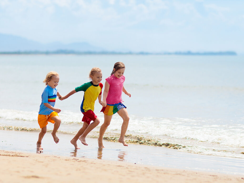 Trois enfants qui courent sur la plage
