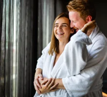 Un couple souriant qui profite de la saint-valentin pour passer un momment de détente dans un spa.