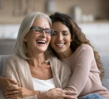 Une mère âgée et sa fille adulte s'amusent à la maison, sont assises sur le canapé, s'amusent et passe un bone momment à l'occasion de la fête des mères.