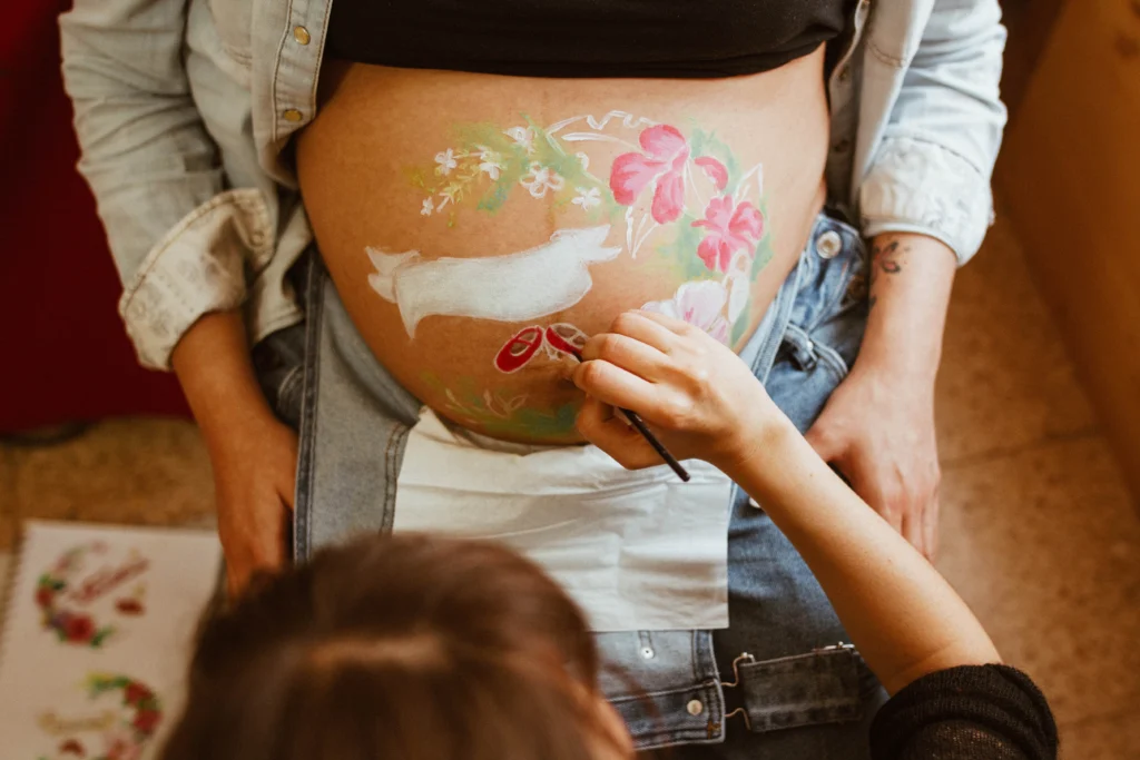 Peinture à la main sur le ventre d'une femme enceinte. 