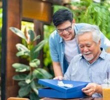 Un homme surprend son père âgé avec un cadeau drôle à la fête des pères dans un café-restaurant en plein air.