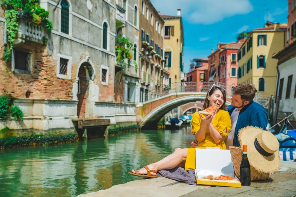 Couple en lune de miel sur la jetée avec une vue magnifique sur les canaux de Venise en Italie.