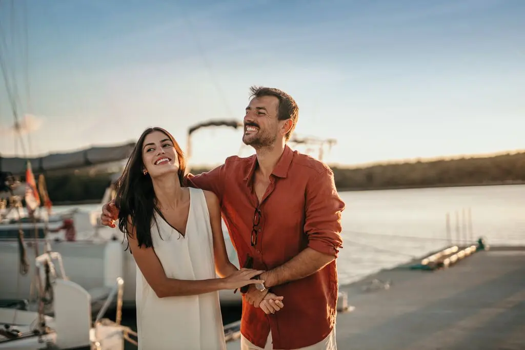 Un jeune couple se détendant ensemble sur la promenade au bord de la mer. Cadeau de noël pour parents.
