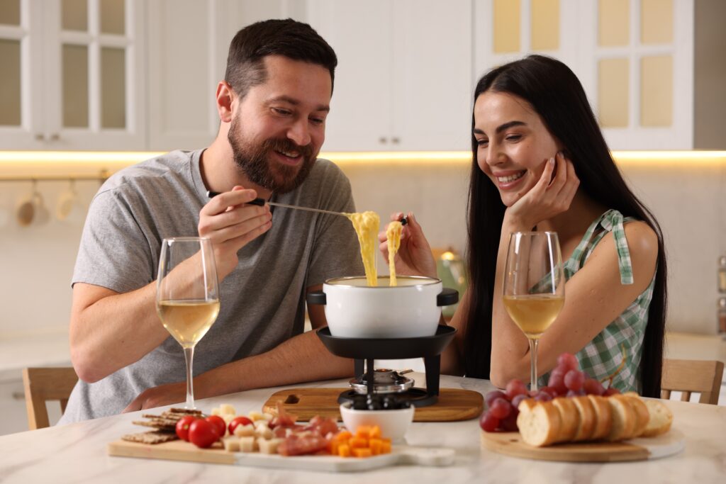 Couple affectueux dégustant une fondue de fromage lors de la Saint-Valentin.