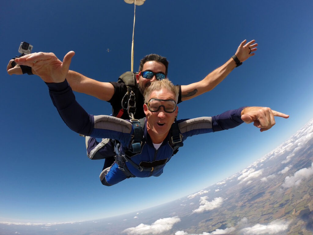 Hombre de mediana edad saltando en paracaídas