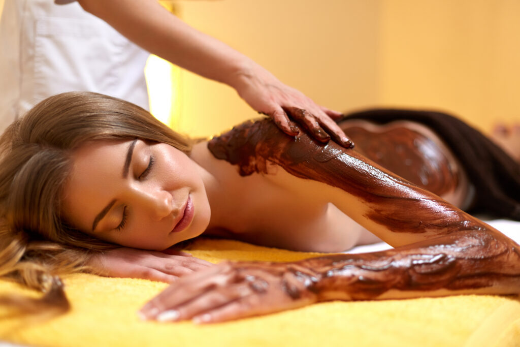 Mujer en un spa recibiendo un masaje de chocolate