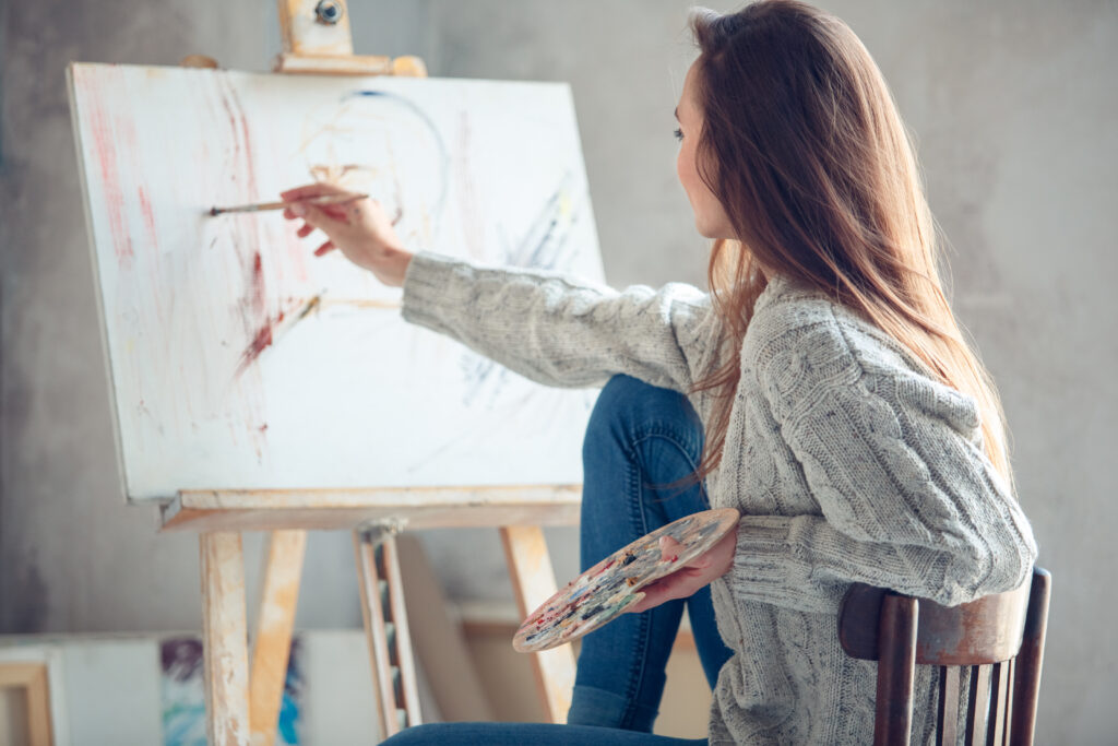Mujer pinta cuadro en casa