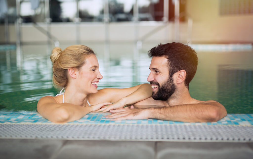 Una pareja sonriendo cómplice mientras disfruta del relax en un spa