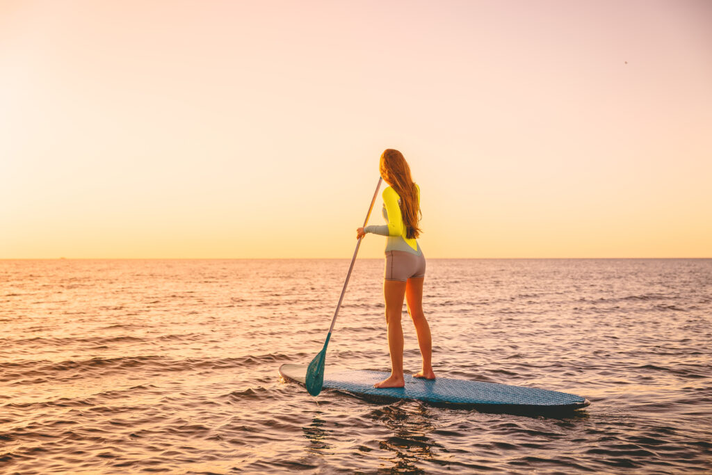 Chica joven practicando paddle surf