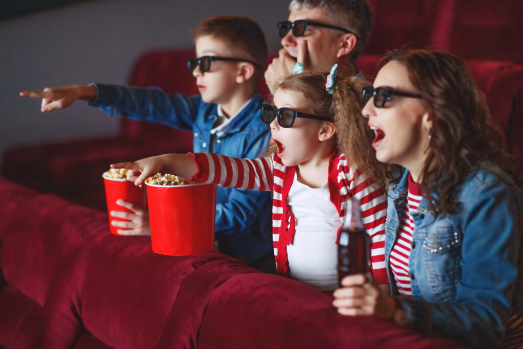 Familia asombrada viendo una película en 3D en el cine