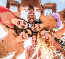 Grupo de seis amigos en círculo con trajes de baño