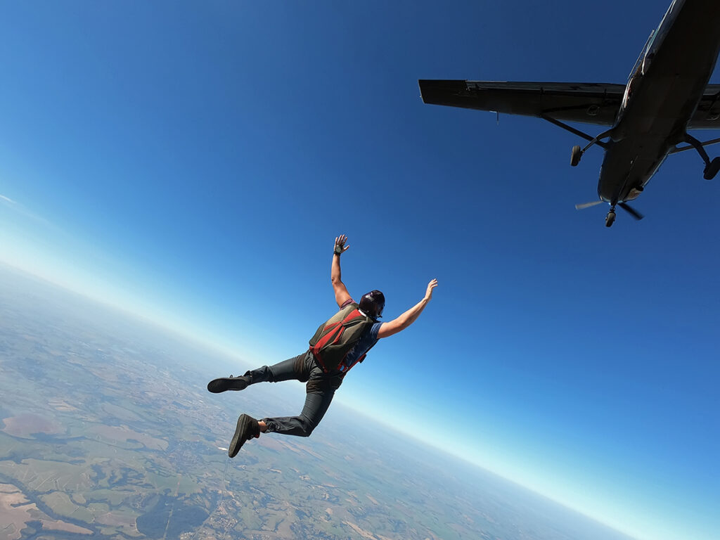 Persona tirándose en paracaídas desde una avioneta