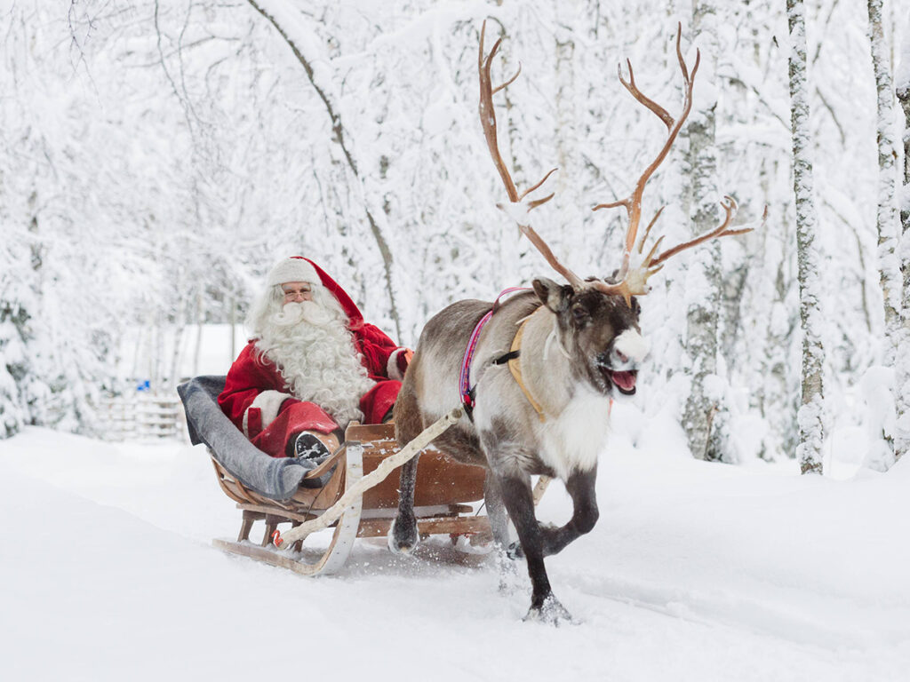 Papá Noel llevando un trineo con reno