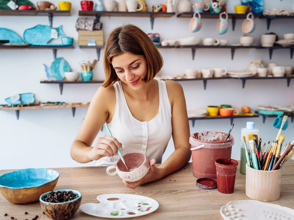 Una chica pintando una taza de cerámica