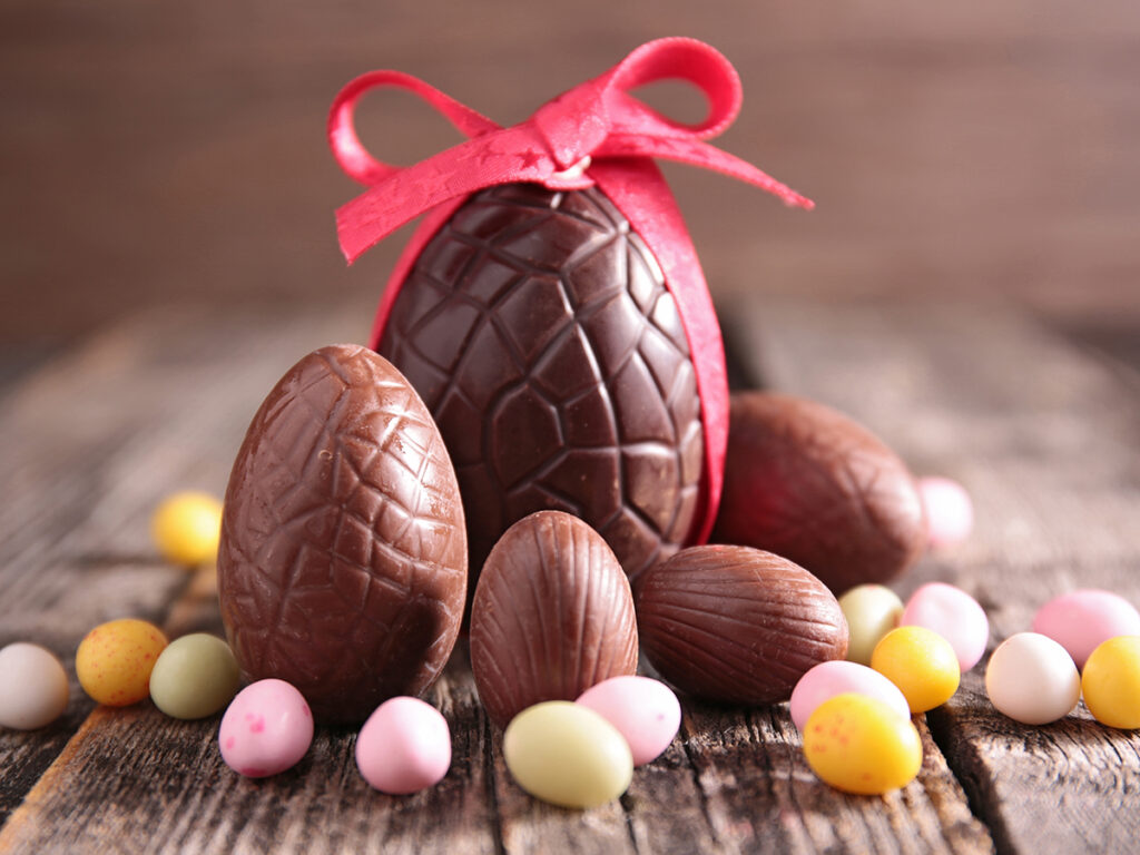 Grands et petits œufs de Pâques en chocolat décorés de rubans