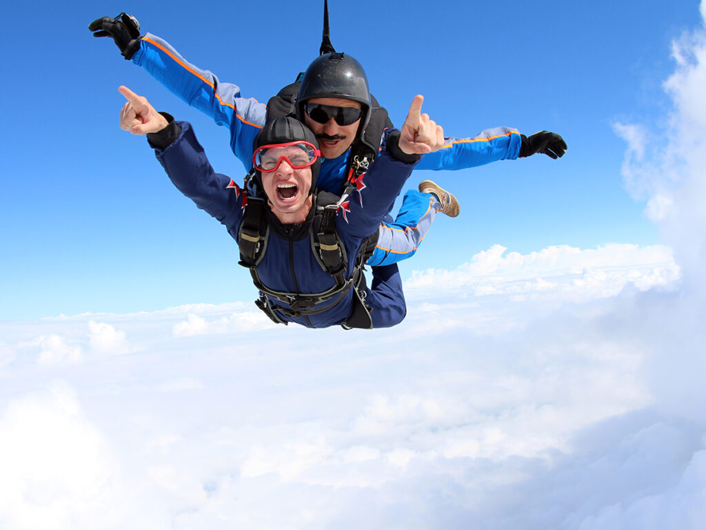 Deux hommes sautant en parachute en tandem sur fond de nuages
